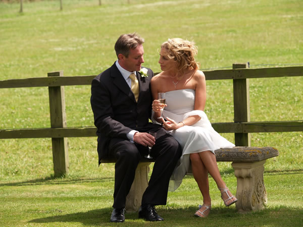 Bride and groom sat on a bench